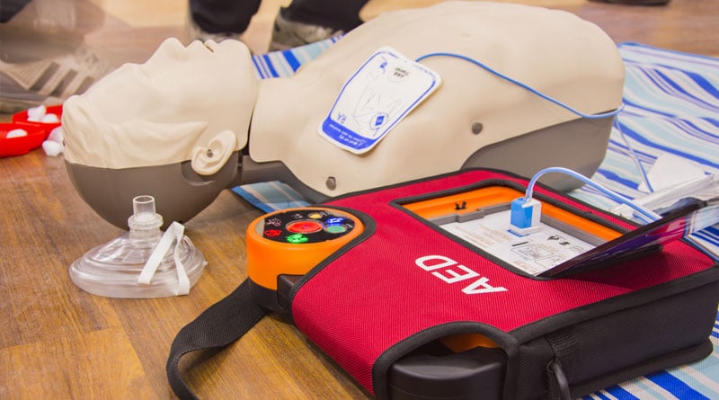 Defibrillator On Dummy With Towel Online CPR Certification