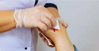Healthcare provider wiping blood from patient hands