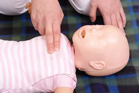 Learner practising CPR on infant mannequin 